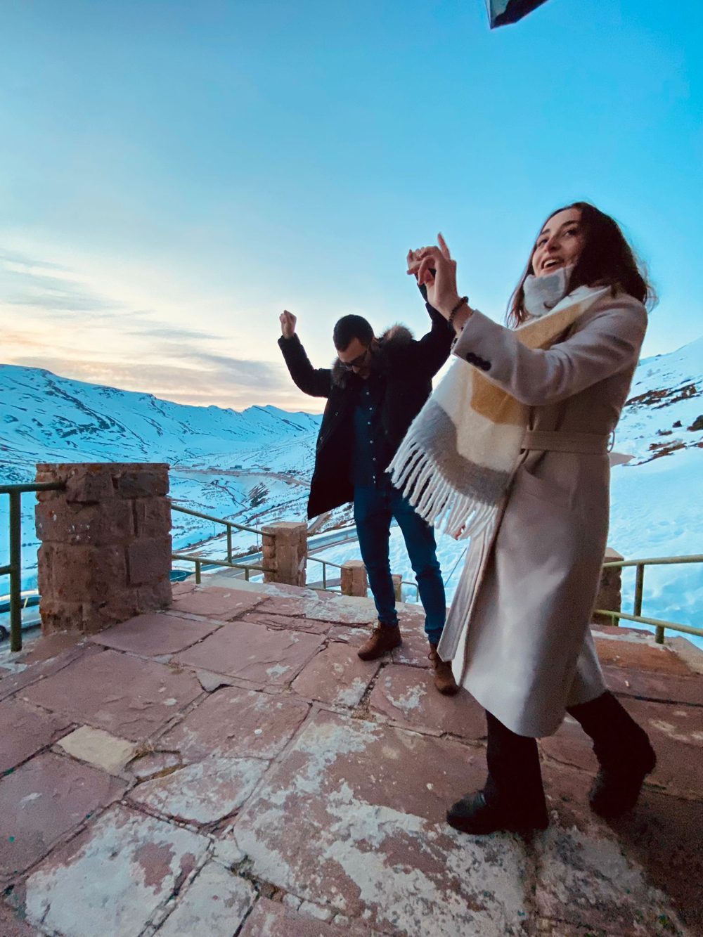 Carlos y Diana bailando en un mirador con montañas nevadas al atardecer